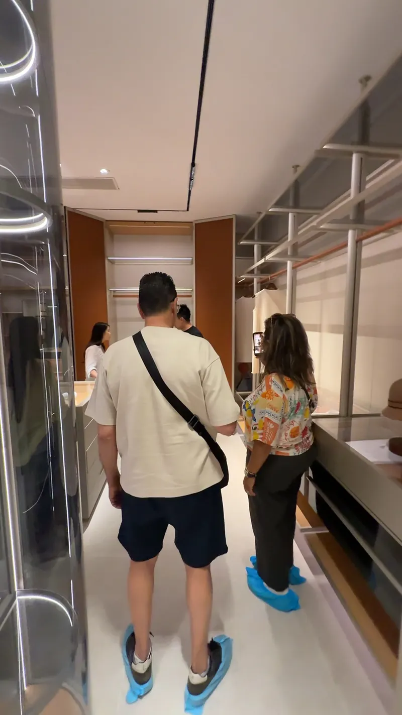Visitors stand among cabinet displays while a person holds up a phone.